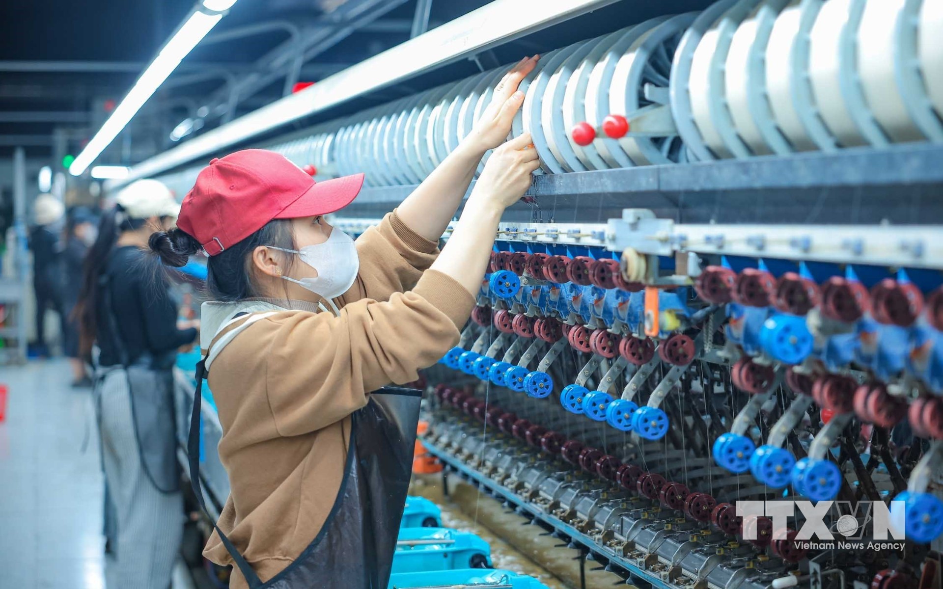 Công nhân làm việc trên dây chuyền ươm tơ hiện đại của nhà máy Công ty Cổ phần Dâu tằm tơ Yên Bái. (Ảnh: Hoàng Hiếu/TTXVN)